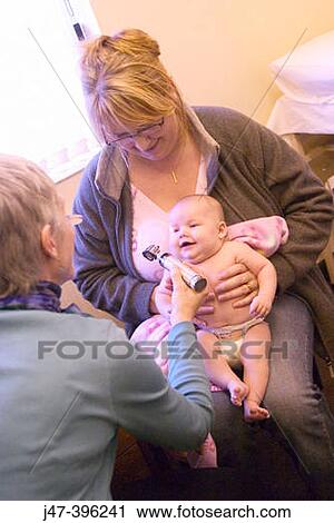 Stock Image - 8 week old baby at doctors surgery, having her first health check-up. Fotosearch