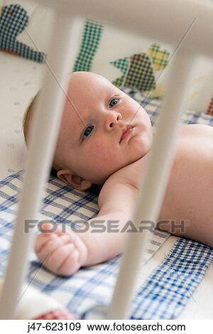 8 week old baby lying in his cot, looking serious. View Large Photo Image Stock Photo - 8 week old baby lying in his cot, looking serious.. Fotosearch