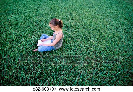 9 year old girl sitting on grass, drawing in notebook View Large Photo Image Stock Photo - 9 year old girl sitting on grass, drawing in notebook. Fotosearch