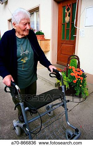 Stock Photograph - 90 year old woman using walking frame. Switzerland. Fotosearch