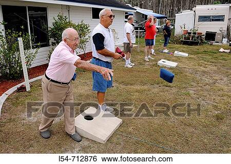 Stock Photograph - 93 year old Senior retired citizens play game of bean bag toss in a recreational vechile camping park in Bonita Springs Florida. Fotosearch