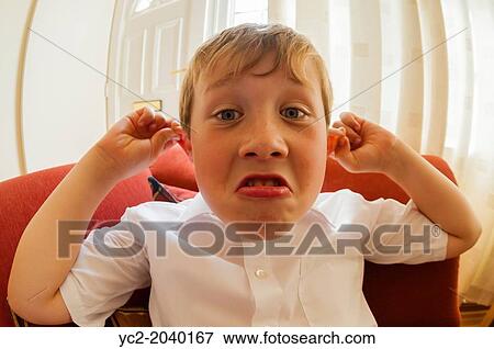 Stock Photo - A 10 year old boy pulling a funny face indoors.. Fotosearch