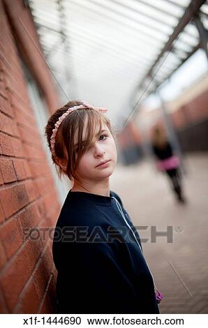 Stock Image - A 12-13 year teenage old girl, alone outdoors UK. Fotosearch