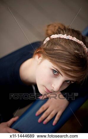 Stock Photo - A 12-13 year teenage old girl, outdoors UK, looking up. Fotosearch