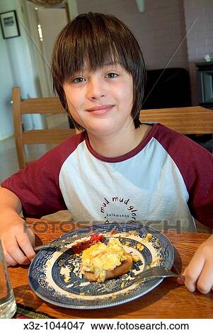 A 12 year old boy eating breakfast View Large Photo Image Stock Photo - A 12 year old boy eating breakfast. Fotosearch