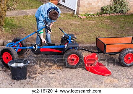 A 12 year old boy washing and cleaning his gocart in the Uk View Large Photo Image Picture - A 12 year old boy washing and cleaning his gocart in the Uk. Fotosearch