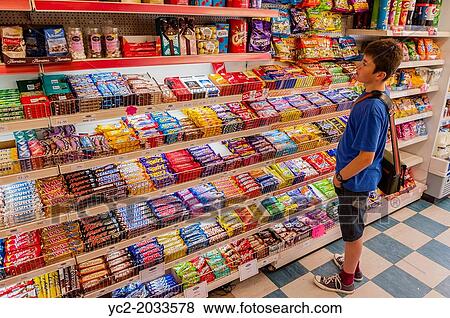 Stock Photo - A 13 year old boy choosing some sweets in a shop store in the Uk.. Fotosearch
