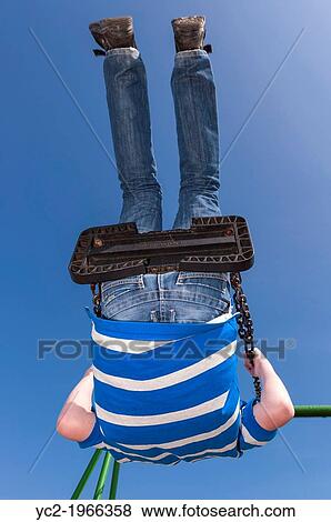 A 13 year old boy going very high on a swing showing movement in the Uk. View Large Photo Image Stock Photo - A 13 year old boy going very high on a swing showing movement in the Uk.. Fotosearch