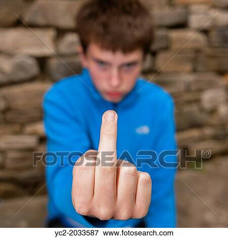 A 13 year old teenage boy being rude by sticking his middle finger up at the camera outside. View Large Photo Image Stock Photo - A 13 year old teenage boy being rude by sticking his middle finger up at the camera outside.. Fotosearch