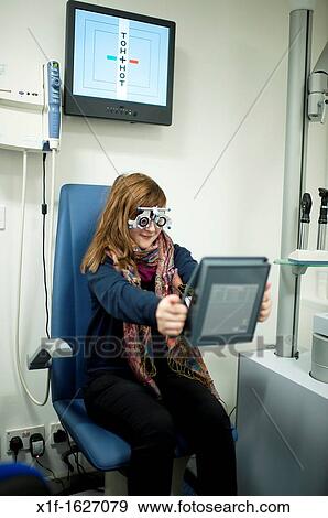 A 13 year old teenage girl having her eyes tested at an opticians, UK View Large Photo Image Stock Photo - A 13 year old teenage girl having her eyes tested at an opticians, UK. Fotosearch