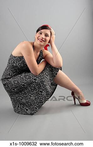 A 20-something attactive female in a sleeveless dress with a red ribbon in her hair and expressive hand gestures View Large Photo Image Stock Image - A 20-something attactive female in a sleeveless dress with a red ribbon in her hair and expressive hand gestures. Fotosearch