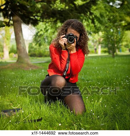 a 20 year old woman photographer wearing red jumper kneeling down taking a photo with a Camnon digital camera UK View Large Photo Image Stock Image - a 20 year old woman photographer wearing red jumper kneeling down taking a photo with a Camnon digital camera UK. Fotosearch