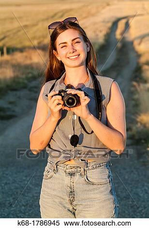 A 20 year old woman with a camera View Large Photo Image Stock Photography - A 20 year old woman with a camera. Fotosearch