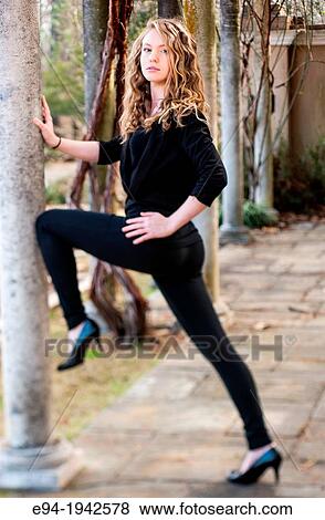 A 22 year old blond woman stretching legs leaning against a column. View Large Photo Image Stock Photo - A 22 year old blond woman stretching legs leaning against a column.. Fotosearch