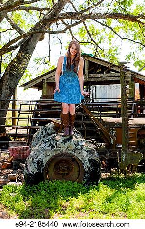A 22 year old brunette woman jumping off of the tire of an old farm tractor, outdoors. View Large Photo Image Stock Image - A 22 year old brunette woman jumping off of the tire of an old farm tractor, outdoors.. Fotosearch