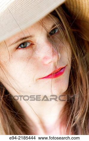 A 22 year old brunette woman wearing a straw hat looking directly at the camera, outdoors. View Large Photo Image Picture - A 22 year old brunette woman wearing a straw hat looking directly at the camera, outdoors.. Fotosearch