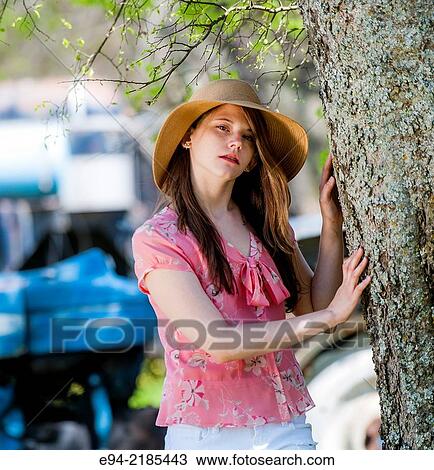 A 22 year old brunette woman wearing a straw hat looking directly at the camera, outdoors. View Large Photo Image Stock Image - A 22 year old brunette woman wearing a straw hat looking directly at the camera, outdoors.. Fotosearch