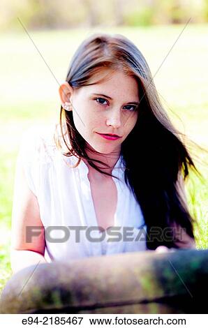 A 22 year old brunette woman wearing a white blouse looking directly at the camera, outdoors. View Large Photo Image Stock Photo - A 22 year old brunette woman wearing a white blouse looking directly at the camera, outdoors.. Fotosearch