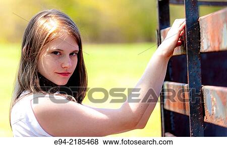 A 22 year old brunette woman wearing a white blouse looking directly at the camera, outdoors. View Large Photo Image Stock Photo - A 22 year old brunette woman wearing a white blouse looking directly at the camera, outdoors.. Fotosearch