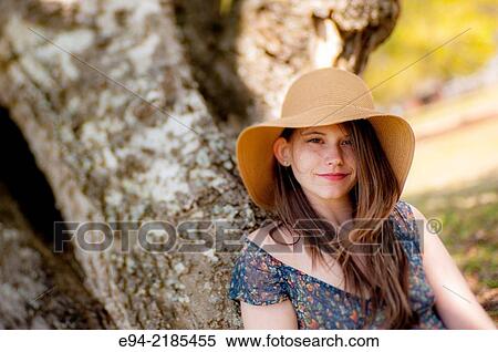 A 22 year old brunette woman wearing a summer dress and a straw hat looking directly at the camera, outdoors. View Large Photo Image Stock Photography - A 22 year old brunette woman wearing a summer dress and a straw hat looking directly at the camera, outdoors.. Fotosearch