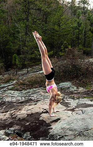 A 23 year old blond woman in work out clothing doing a hand stand in a forest setting. View Large Photo Image Stock Image - A 23 year old blond woman in work out clothing doing a hand stand in a forest setting.. Fotosearch