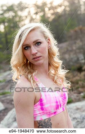A 23 year old blond woman wearing a pink sports bra outside smiling at the camera. View Large Photo Image Stock Image - A 23 year old blond woman wearing a pink sports bra outside smiling at the camera.. Fotosearch