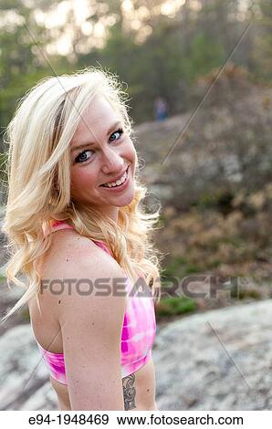 A 23 year old blond woman wearing a pink sports bra outside smiling at the camera. View Large Photo Image Stock Photo - A 23 year old blond woman wearing a pink sports bra outside smiling at the camera.. Fotosearch