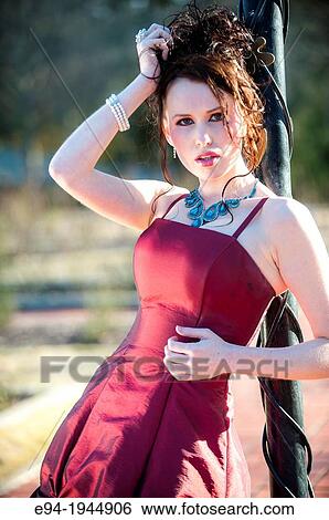 A 24 year old brunette woman in a fancy red dress and high heels on a sunny day outdoors. View Large Photo Image Stock Photograph - A 24 year old brunette woman in a fancy red dress and high heels on a sunny day outdoors.. Fotosearch