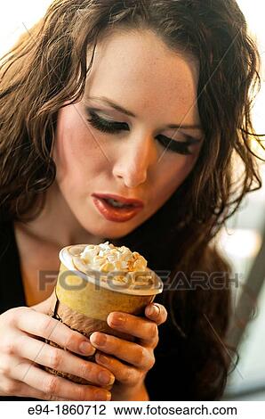 Stock Image - A 24 year old brunette woman relaxing in a coffee shop. Fotosearch
