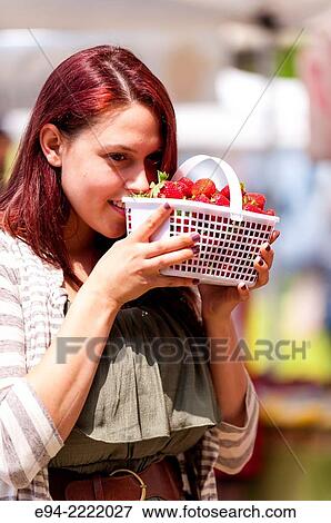 A 24 year old brunette woman smelling fresh strawberries in an outdoor market. View Large Photo Image Stock Photo - A 24 year old brunette woman smelling fresh strawberries in an outdoor market.. Fotosearch