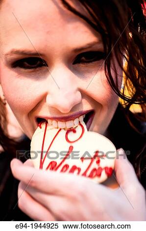 A 24 year old brunette woman smiling at the camera holding a cookie. View Large Photo Image Stock Photography - A 24 year old brunette woman smiling at the camera holding a cookie.. Fotosearch