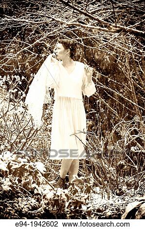 A 24 year old woman wearing a white dress standing in a garden during a snow storm. View Large Photo Image Stock Image - A 24 year old woman wearing a white dress standing in a garden during a snow storm.. Fotosearch