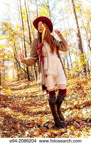 Picture - A 25 year old red headed woman in a forest setting in the autumn.. Fotosearch