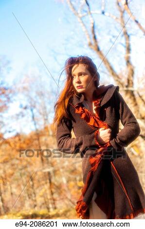 Stock Image - A 25 year old red headed woman in a forest setting in the autumn.. Fotosearch