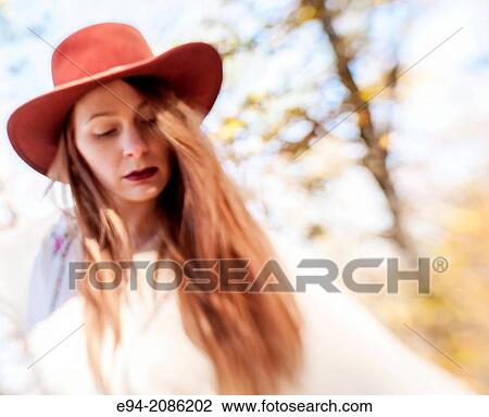 Stock Image - A 25 year old red headed woman in a forest setting in the autumn.. Fotosearch