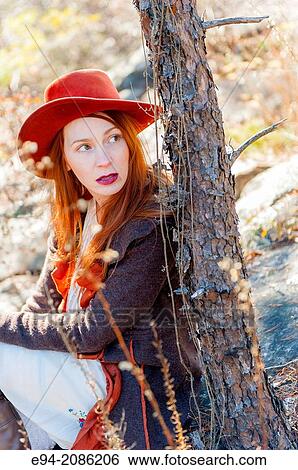 A 25 year old red headed woman wearing a hat in a forest setting in the autumn looking away from the camera. View Large Photo Image Stock Photograph - A 25 year old red headed woman wearing a hat in a forest setting in the autumn looking away from the camera.. Fotosearch
