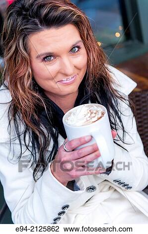 A 27 year old brunette woman holding a white mug of hot chocolate looking at the camera. View Large Photo Image Stock Image - A 27 year old brunette woman holding a white mug of hot chocolate looking at the camera.. Fotosearch