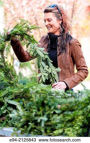 A 27 year old brunette woman outdoors shopping for evergreen garland. View Large Photo Image Stock Image - A 27 year old brunette woman outdoors shopping for evergreen garland.. Fotosearch