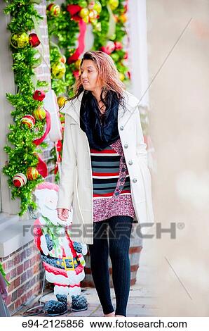 A 27 year old brunette woman shopping on a small town street with holiday decorations. View Large Photo Image Stock Photograph - A 27 year old brunette woman shopping on a small town street with holiday decorations.. Fotosearch