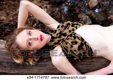 A 29 year old blond woman in a forest lying a on log wearing blue jeans and a leopard top View Large Photo Image Stock Photo - A 29 year old blond woman in a forest lying a on log wearing blue jeans and a leopard top. Fotosearch