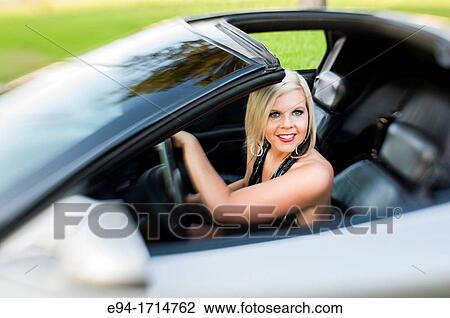 A 29 year old blond woman in the driver's seat of a sports car smiling at the camera View Large Photo Image Stock Image - A 29 year old blond woman in the driver's seat of a sports car smiling at the camera. Fotosearch