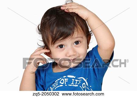 Stock Image - A 3 year old boy holding his head. Pune India. Fotosearch
