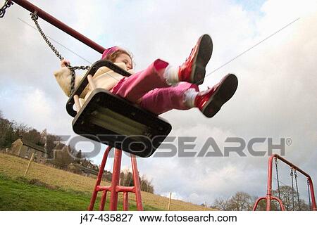 A 3 year old girl swinging high up on a swing View Large Photo Image Stock Photo - A 3 year old girl swinging high up on a swing. Fotosearch