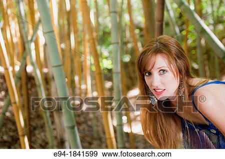 A 30 year old redheaded woman in a bamboo forest wearing jeans and a shimmy top View Large Photo Image Stock Photo - A 30 year old redheaded woman in a bamboo forest wearing jeans and a shimmy top. Fotosearch