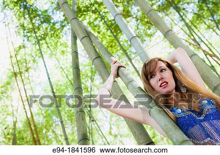 A 30 year old redheaded woman in a bamboo forest wearing jeans and a shimmy top View Large Photo Image Stock Photograph - A 30 year old redheaded woman in a bamboo forest wearing jeans and a shimmy top. Fotosearch