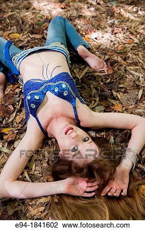 A 30 year old redheaded woman lying on the ground in a bamboo forest wearing jeans and a shimmy top View Large Photo Image Stock Image - A 30 year old redheaded woman lying on the ground in a bamboo forest wearing jeans and a shimmy top. Fotosearch