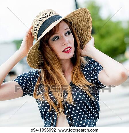 A 31 year old red headed woman in an urban setting wearing a straw hat and a mid drift top looking away from the camera. View Large Photo Image Stock Image - A 31 year old red headed woman in an urban setting wearing a straw hat and a mid drift top looking away from the camera.. Fotosearch