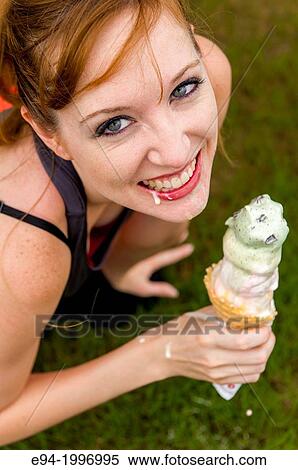 A 31 year old red headed women in casul clothiing eating an ice cream cone. View Large Photo Image Stock Photography - A 31 year old red headed women in casul clothiing eating an ice cream cone.. Fotosearch