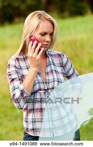 A 35 year old blond woman talking on a mobile phone in a country setting. View Large Photo Image Stock Photo - A 35 year old blond woman talking on a mobile phone in a country setting.. Fotosearch