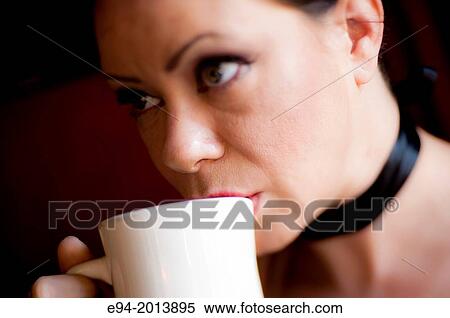 A 35 year old brunette woman holding a coffee cup in a cafe. View Large Photo Image Stock Photography - A 35 year old brunette woman holding a coffee cup in a cafe.. Fotosearch